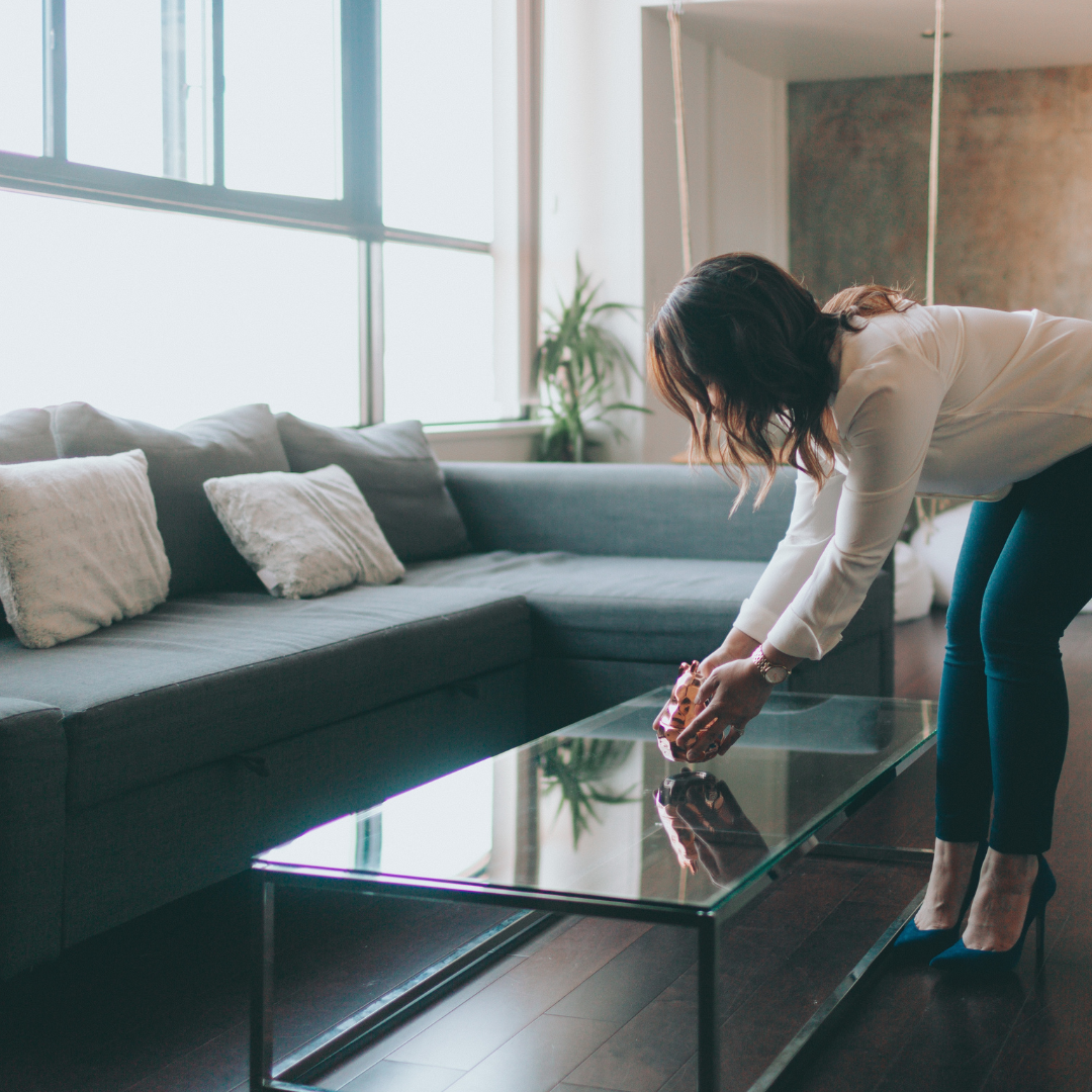 a woman staging her home, placing a decoration on the coffee table