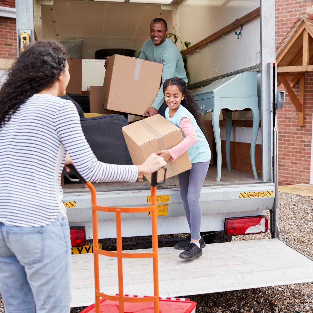 Family of three moving boxes in a truck and relocating.
